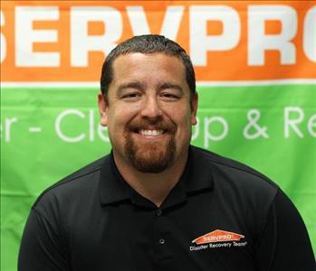 Male with brown hair and a beard in a SERVPRO shirt in front of a SERVPRO banner