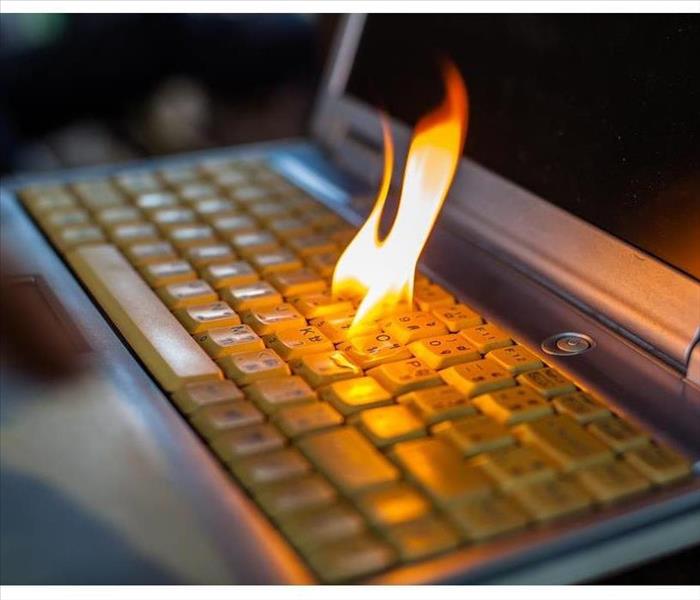 Flame coming out a computer keyboard. Concept of electronics damaged by fire.
