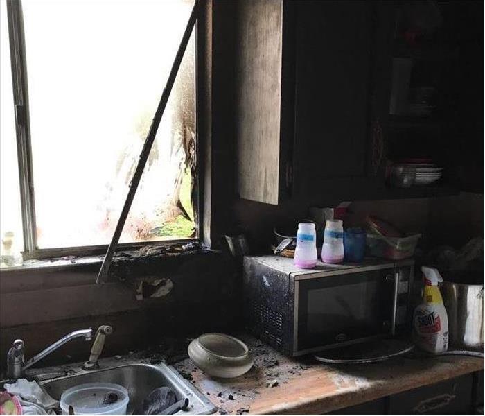 Kitchen area, sink washer, window frame damaged by fire, also a microwave damaged by fire.